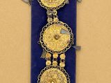 une vitrine bleue ornée de trois médaillons dorés