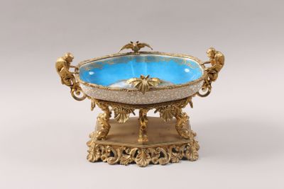 gold and blue glass bowl on stand on white background