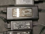 three laptop power adapts and a charger on a table