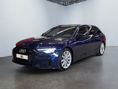 Une Audi bleue est garée dans une grande pièce au plafond noir