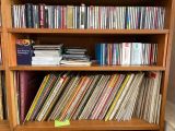 a wooden bookcase filled with various cd ' s and cds