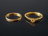 two gold rings on a black surface