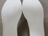 the soles of a pair of white slippers on a beige surface