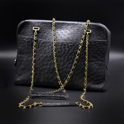 a black purse with gold chains on a black background