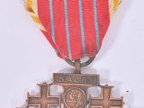 a medal with a cross on it on a white surface