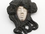 une photo en noir et blanc représentant le visage d'une femme avec des fleurs dans les cheveux
