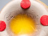 a close up of a donut with red dots on it