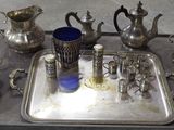 un plateau en argent sur lequel sont posés des objets en argent, posé sur un comptoir