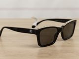 chanel sunglasses on a wooden table with a white background