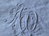 embroidered monograms on a bed sheet with a crown on top of it