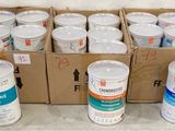 plusieurs pots de peinture blanche posés sur une boîte en carton