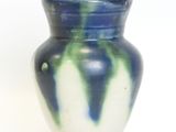 a blue and white vase sitting on a white surface