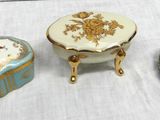 Trois petites boîtes sont posées sur une table recouverte d'une nappe blanche.