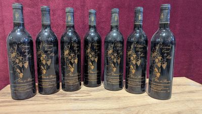 six bottles of wine sitting on top of a wooden table