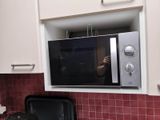 someone is taking a picture of themselves in a microwave in a kitchen