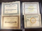 Quatre certificats sont exposés dans une vitrine posée sur une table