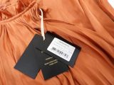 an orange dress with a black label on it and a tag on it