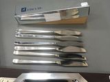 five knives and a tray sitting on a table