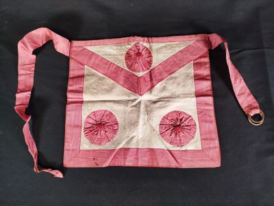 un vieux sac rose et blanc orné d'un ruban rose sur fond noir