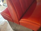 a red bench that is sitting in the corner of a room
