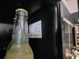 a bottle of soda sitting on a counter next to a refrigerator