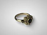 gros plan d'une bague en or avec une pierre noire