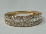 a close up of a gold ring with baguets of diamonds