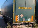 two semi trucks that are parked on the side of the road