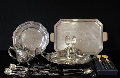 un plateau en argent et des couverts en argent posés sur une table noire