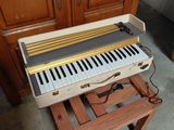a piano that is sitting on a stand in front of a cabinet