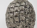 a silver pineapple shaped object on a white background
