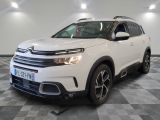 Le SUV Citrole blanc est garé dans une grande pièce.