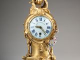 une horloge en or surmontée d'un oiseau