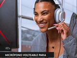 smiling woman with headphones on using a computer in front of a window