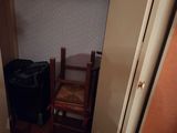a closet with a chair and a trash can in it