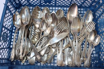 un panier bleu rempli de cuillères en argent et de cuillères