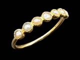 a close up of a gold ring with pearls on a black background