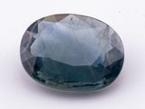 a close up of a blue sapphire stone on a white surface
