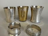 three silver cups are sitting on a table next to each other