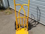 a yellow hand truck that is parked in front of a garage