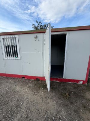 an open white and red container sitting on top of a dirt field