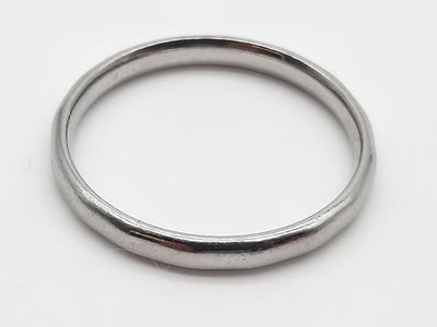 une image montrant un gros plan d'une bague en argent posée sur une surface blanche