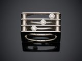 une bague en or blanc sertie de trois diamants sur fond noir