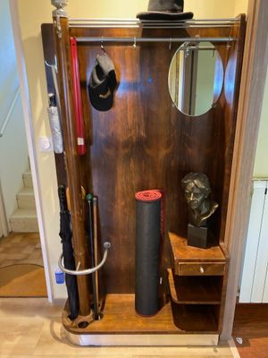 a wooden cabinet with a mirror and a hat on it
