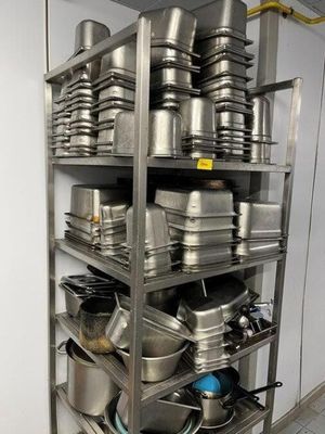 many pots and pans on the shelves in the kitchen
