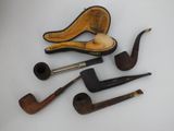 a lot of different types of smoking pipes on the table