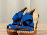 pair of blue and brown wedged sandals on a wooden table