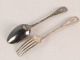 two spoons and a fork on a white surface