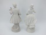 pair of white porcelain figurines of a woman and a man