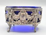 an antique silver and blue glass bowl sitting on top of a table